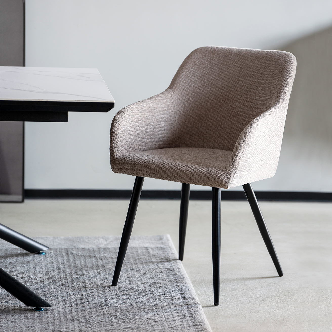 Silla de comedor Frazer con reposabrazos, tapizada en lino beige y estructura de metal negro, perfecta para comedores modernos