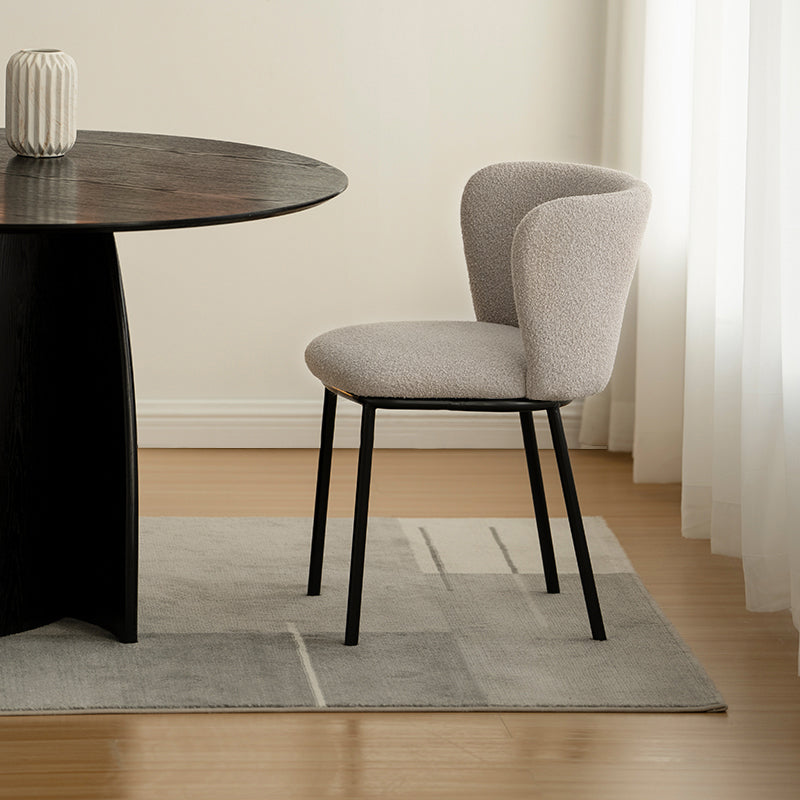 Silla de comedor Karin en tejido bouclé beige, con respaldo alto y patas de metal negro. Perfecta para comedor, cocina o oficina en casa. Colección OFCASA.