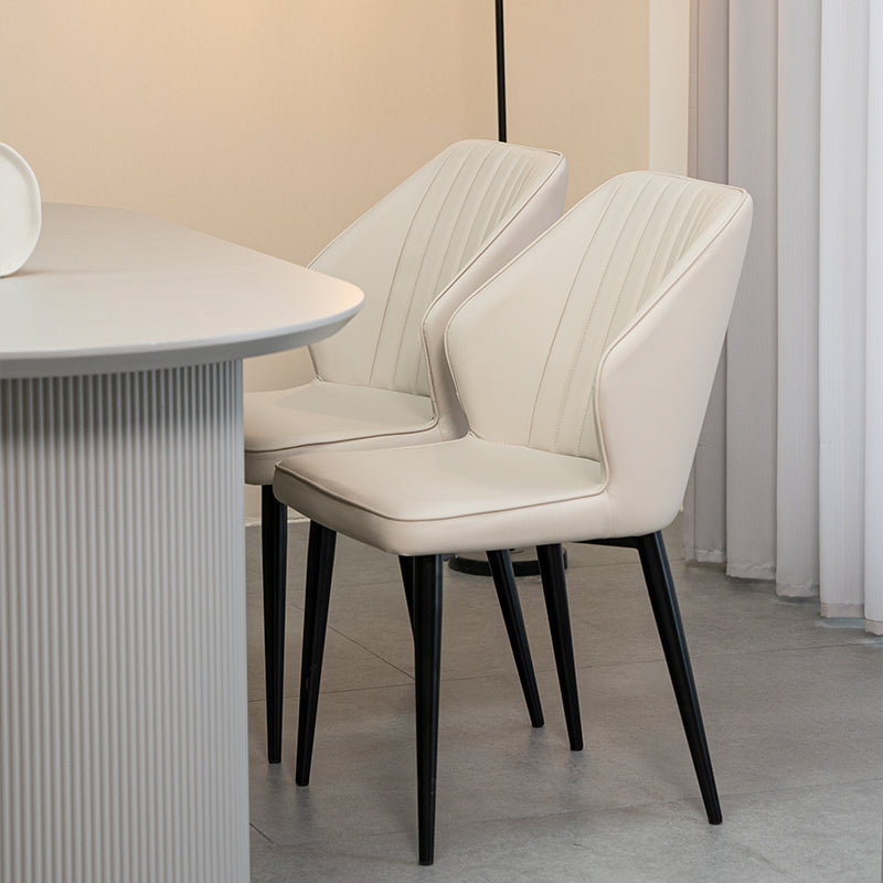 Silla de comedor Aleena en un entorno real, combinada con una mesa de madera y decoración cálida. Perfecta para comidas familiares o cenas formales.
