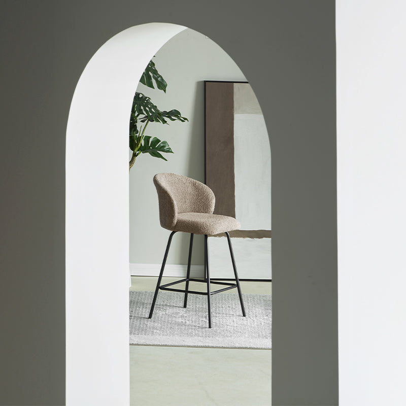 Taburete giratorio Yasin UDC23121 en tejido bouclé, altura 65 cm, ideal para islas de cocina o bares. Respaldo acolchado y estructura metálica resistente.