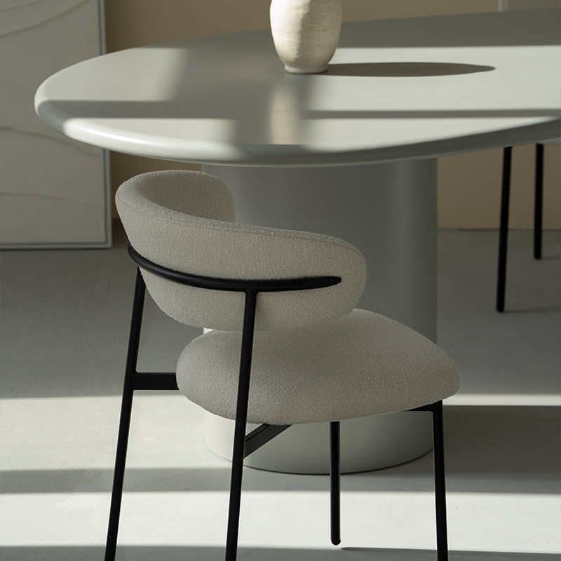 Silla de comedor Zahra en un entorno moderno, junto a mesa de madera y vajilla minimalista