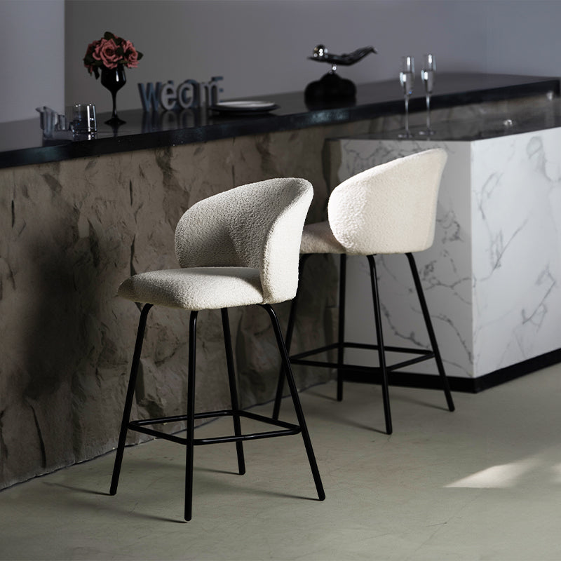 Taburete giratorio Yasin UDC23121 en tejido bouclé, altura 65 cm, ideal para islas de cocina o bares. Respaldo acolchado y estructura metálica resistente.