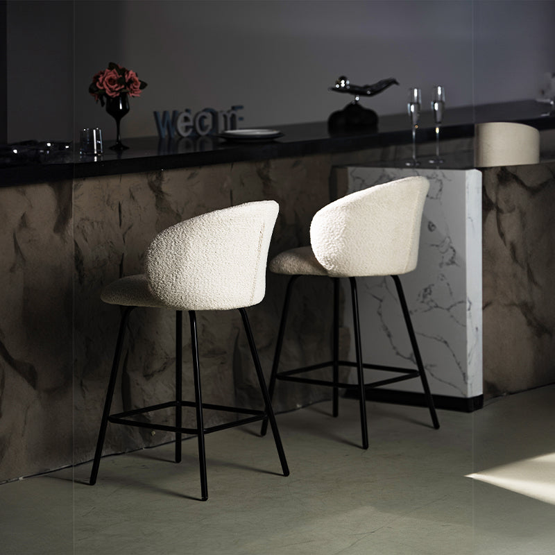 Taburete giratorio Yasin UDC23121 en tejido bouclé, altura 65 cm, ideal para islas de cocina o bares. Respaldo acolchado y estructura metálica resistente.